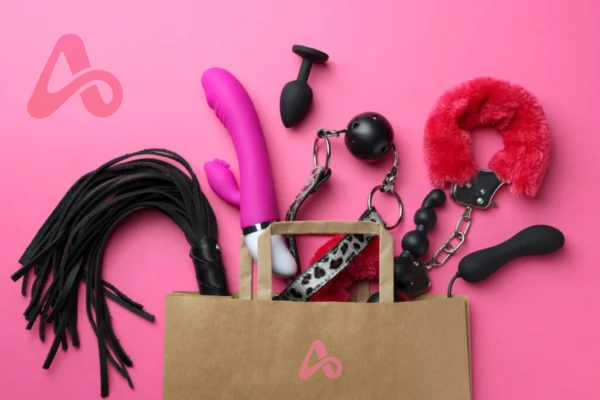 An assortment of AVERO intimacy products spilling from a branded shopping bag on a pink background